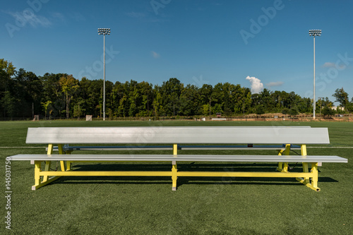 Empty aluminum bench team sports background on a green turf field