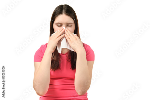 cute girl in pink dress blowing his nose into a paper handkerchief