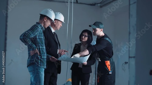 The development group of a project standing and discussing the plan on a site hand shaking then turn on camera and looking straight and snile photo