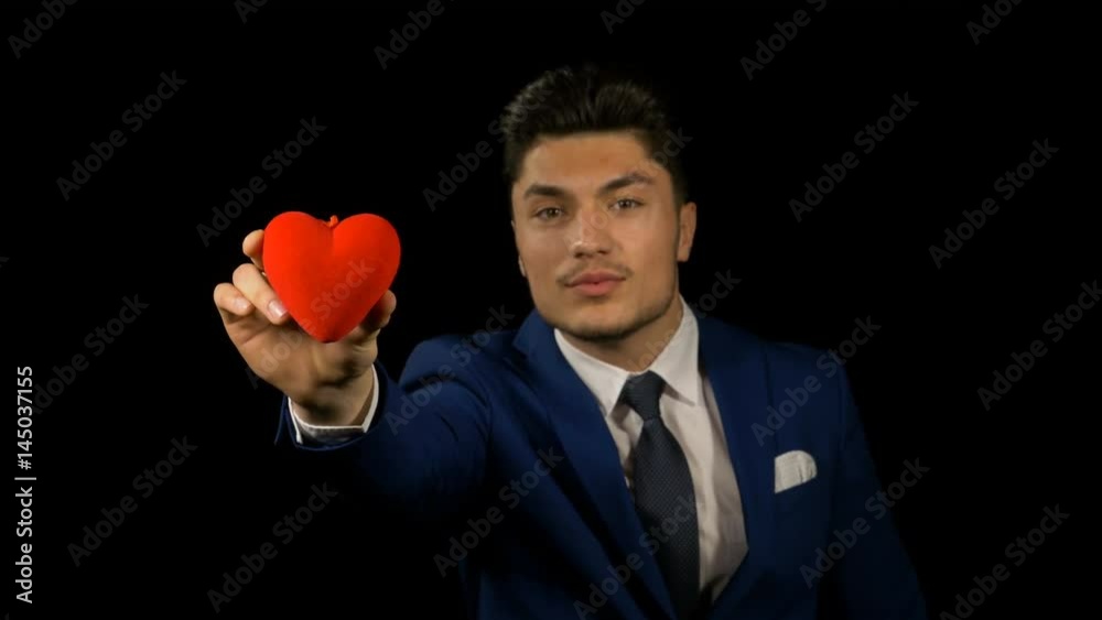 Man holding a small red heart on valentine day Man holding a small red heart on valentine day
