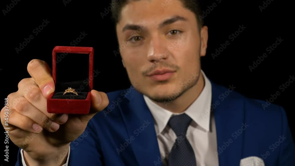 Young handsome boyfriend with proposal ring in hand