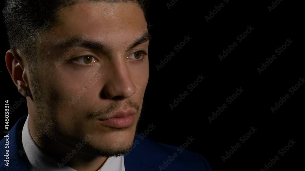 Profile of serious young man on black background Profile of serious young man on black background