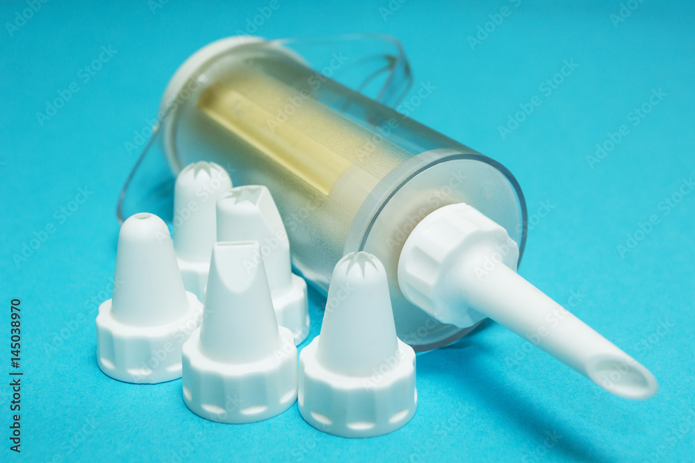 Naklejka premium Set of cream piping nozzles and cream injector (cooking bag) on blue background.