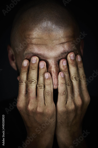 Sad man covered his face with his hands