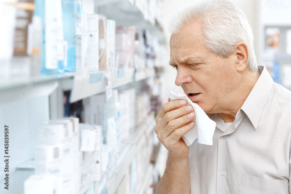 Sick elderly customer choosing medications at the pharmacy