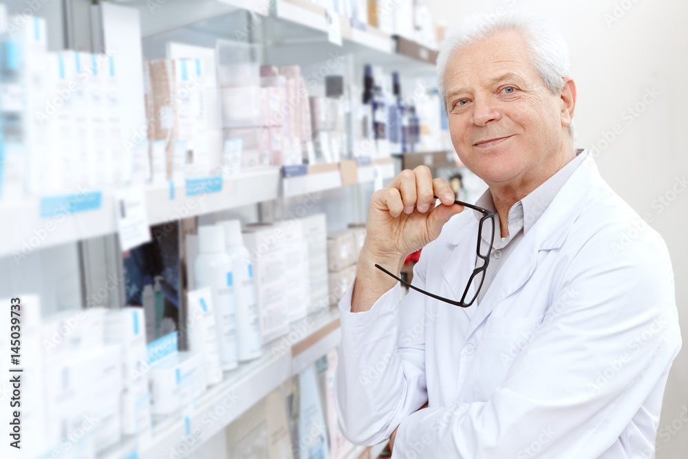 Senior male pharmacist working at his drugstore