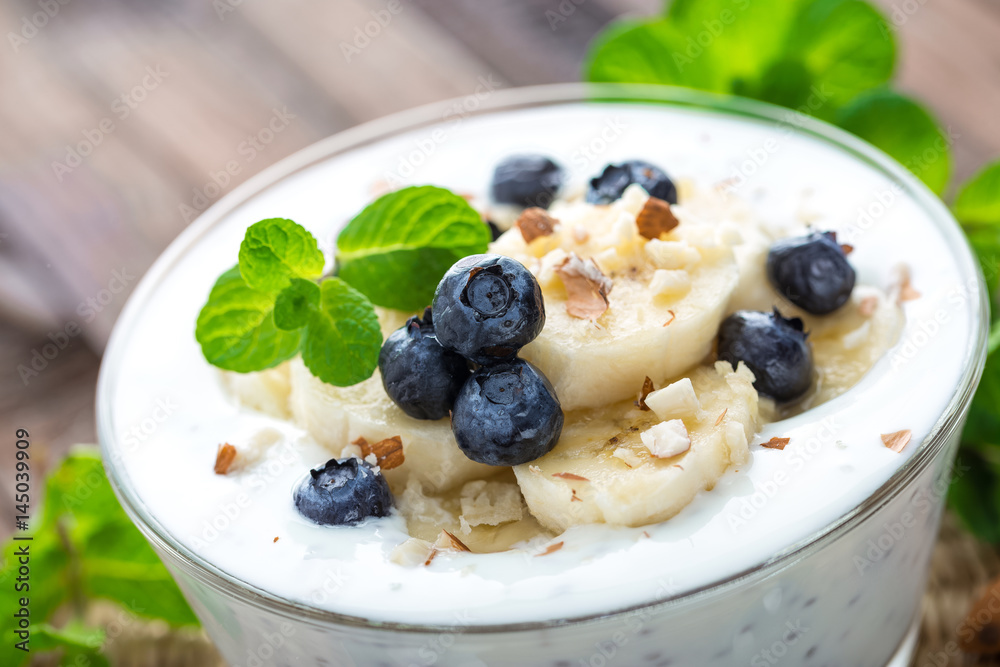 Yogurt with fresh blueberry, banana and almond nuts, delicious dessert for healthy breakfast Yogurt with fresh blueberry, banana and almond nuts, delicious dessert for healthy breakfast