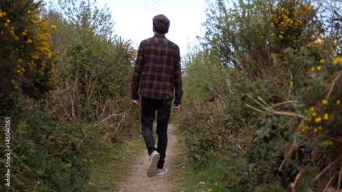 Young man walking along nature path photo