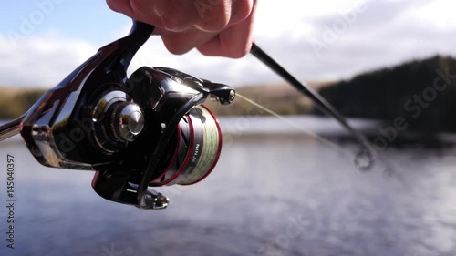 Fisherman reeling in a fish, close up of reel