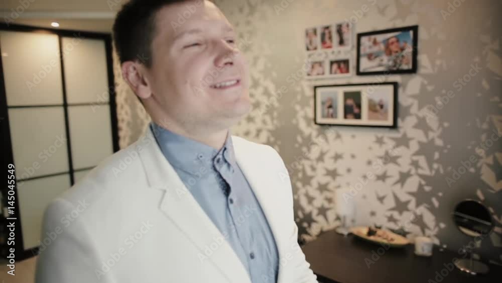 Young attractive man walking through the room, then looking at camera and show the big finger. Hapy smiling guy. Young attractive man walking through the room, then looking at camera and show the big finger. Hapy smiling guy.