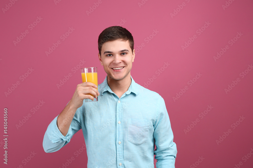 Young man drinking juice on color background Young man drinking juice on color background