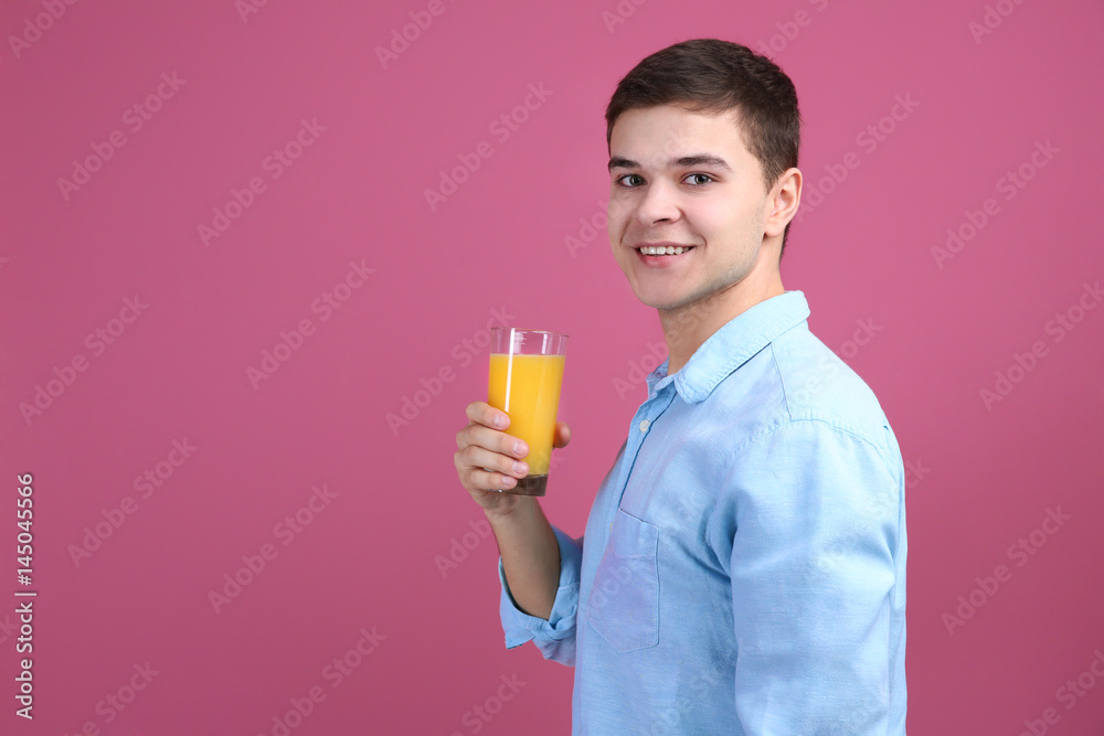 Young man drinking juice on color background Young man drinking juice on color background