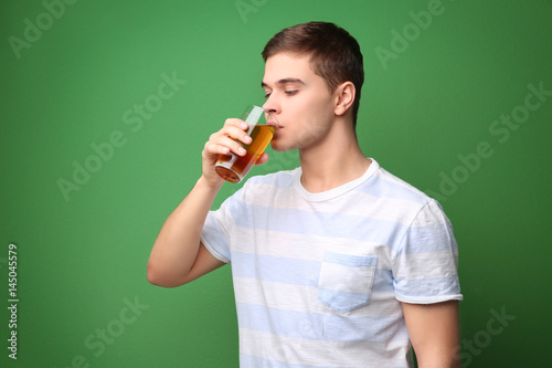 Young man drinking juice on...