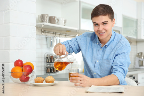 Young man drinking juice on...