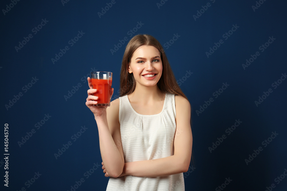 Beautiful young woman with glass of fresh juice on dark blue background Beautiful young woman with glass of fresh juice on dark blue background