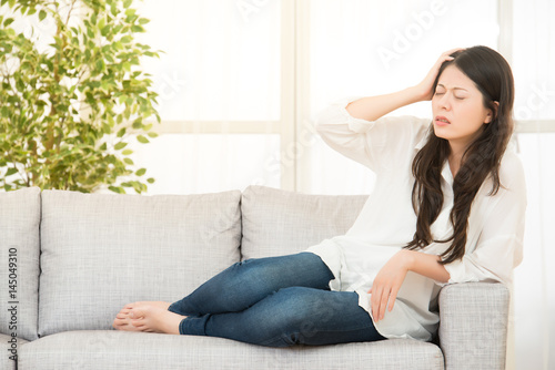 Woman Sitting On Sofa having headache