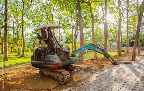 mini blue backhoe work in field site with sunset photo