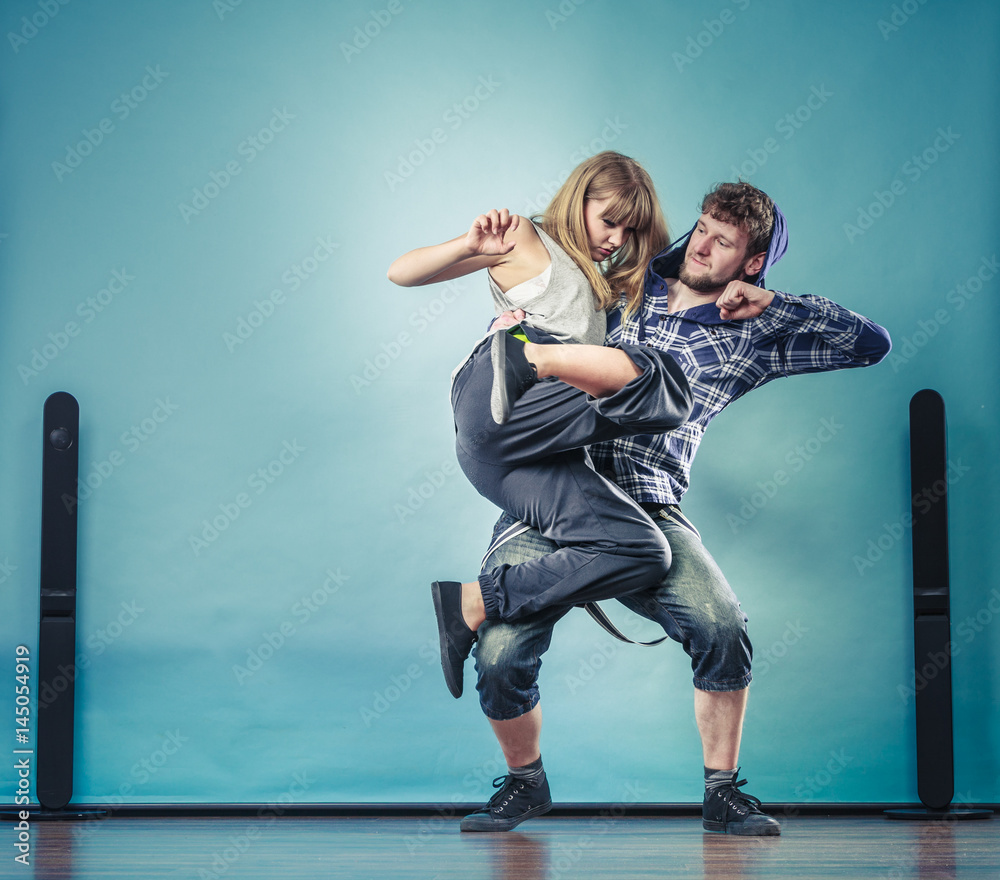 couple of young man and woman dancing hip-hop