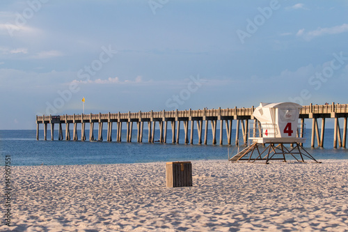 PIer and lifegaurd stand on a beach.