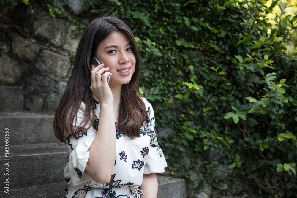 Asian beautiful young woman talking on the phone Asian beautiful young woman talking on the phone