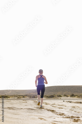 Fitness Lady in Desert Running into the Distance