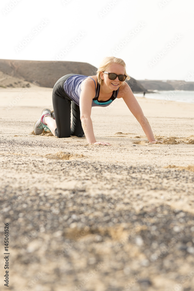 Smiling Fit Woman Doing Push-Ups by the Beach Smiling Fit Woman Doing Push-Ups by the Beach
