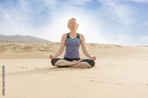 Woman Doing Lotus Pose Yoga in the Desert
