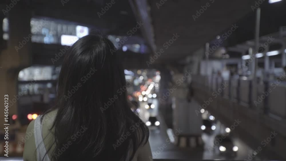 Asian woman walking in urban night scene Asian woman walking in urban night scene