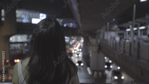 Asian woman walking in urban night scene