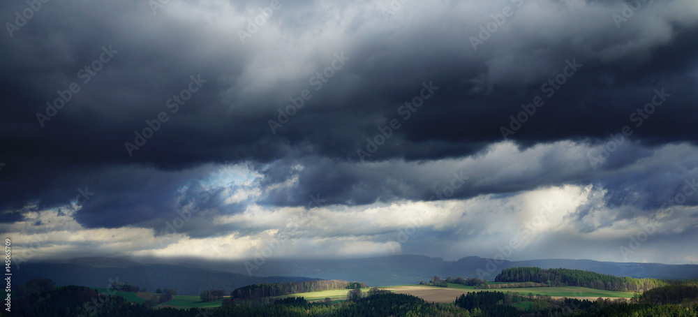 dark rainy clouds and shafts of sunlight