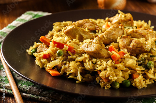 Fried rice nasi goreng with chicken and vegetables on a plate