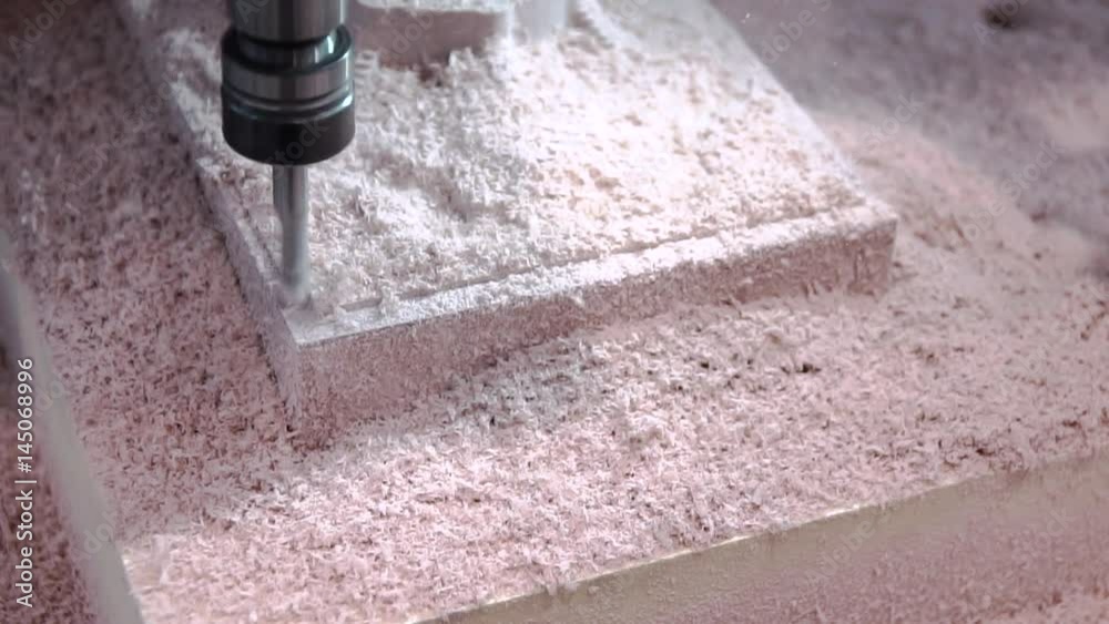 CNC drilling machine. Drills the part from the plastic. The shavings are flying. Modern technologies, composite materials