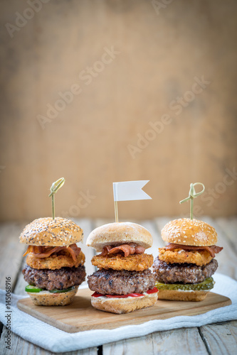 Obraz na płótnie Small beef sliders grilled burgers onion rings little buns bacon served as appetisers for sharing w salonie