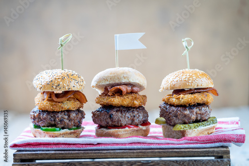 Obraz na płótnie Small beef sliders grilled burgers onion rings little buns bacon served as appetisers for sharing w salonie