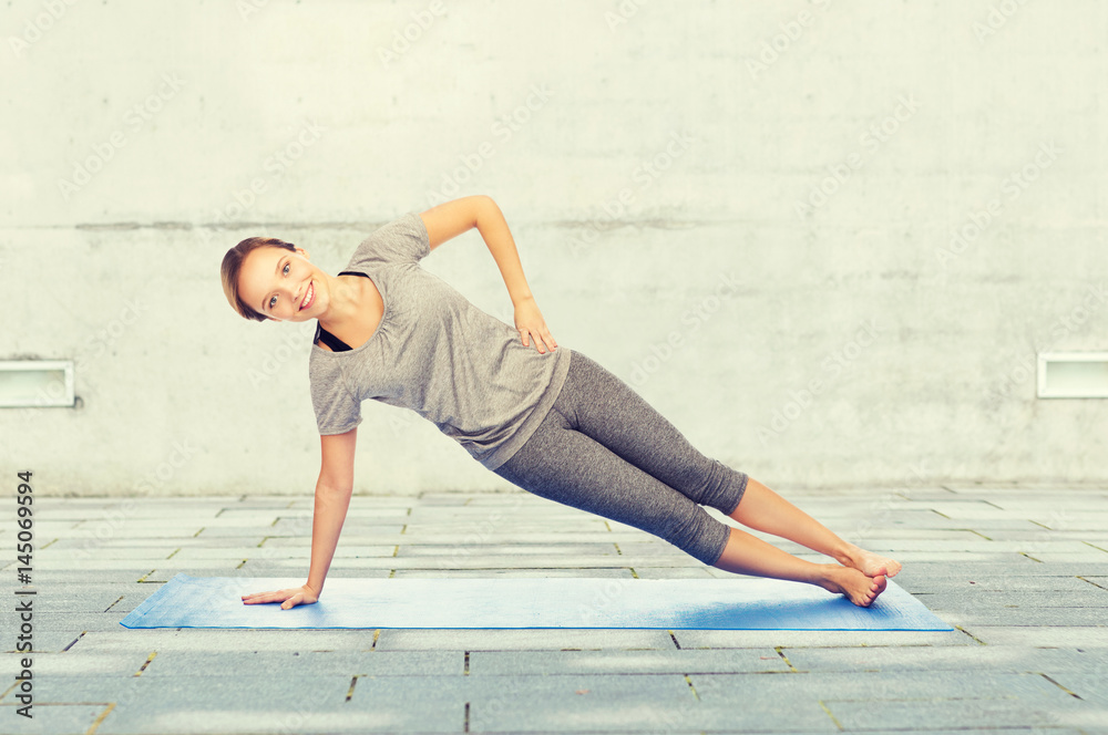 woman making yoga in side plank pose on mat woman making yoga in side plank pose on mat
