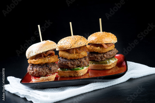 Obraz na płótnie Small beef sliders grilled burgers onion rings little buns bacon served as appetisers for sharing w salonie