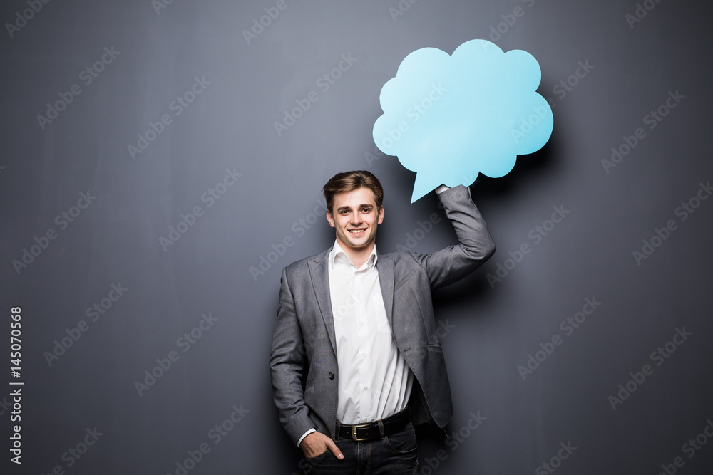 Man holding blue blank speech bubble with space for text on grey background Man holding blue blank speech bubble with space for text on grey background