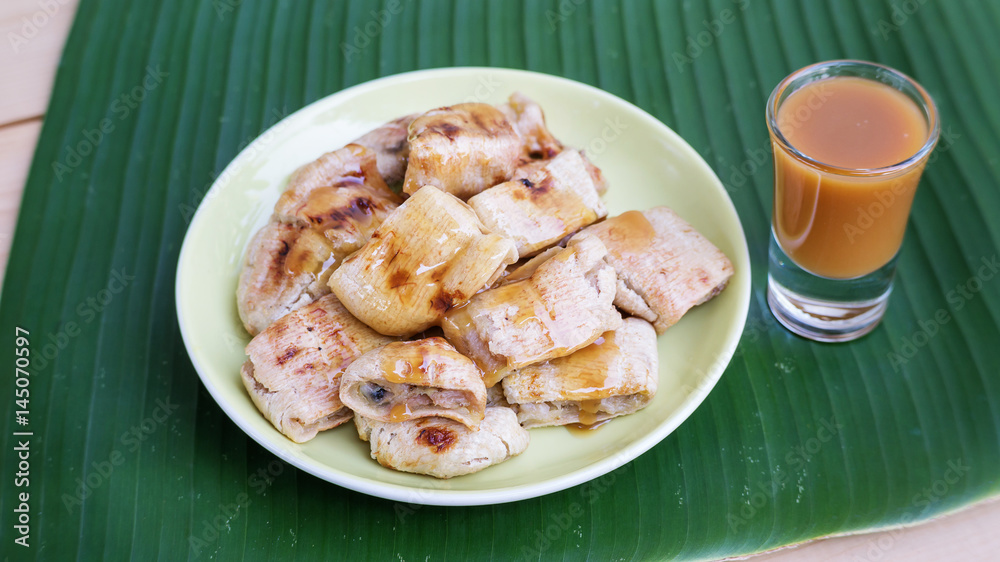 Grilled banana and sweet topping on banana leaves (Thai dessert). Grilled banana and sweet topping on banana leaves (Thai dessert).