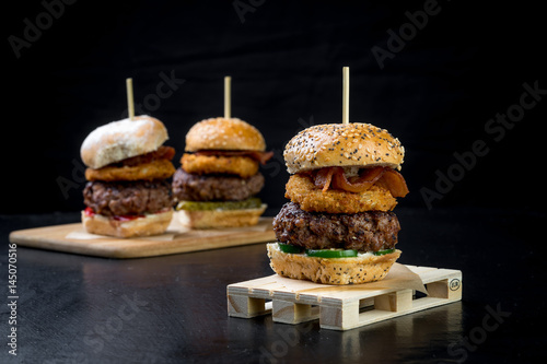 Obraz na płótnie Small beef sliders grilled burgers onion rings little buns bacon served as appetisers for sharing w salonie