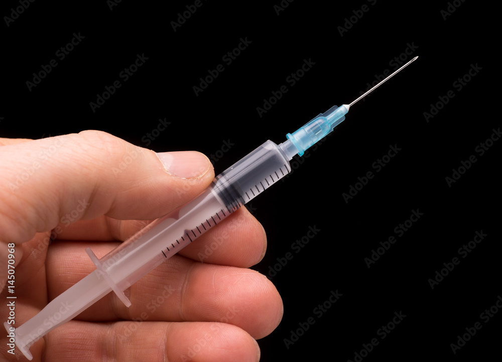 Hand holding a syringe