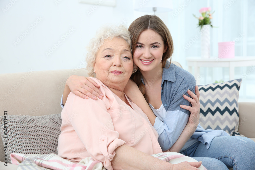 Obraz premium Beautiful girl with grandmother on couch at home