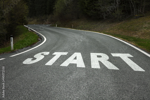 Start word message on the winding curved asphalt country road.