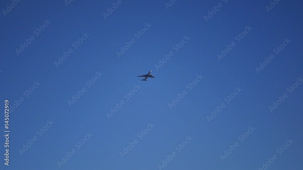 4k, 3840x2160. A large passenger plane flew over the blue clear sky. 4k, 3840x2160. A large passenger plane flew over the blue clear sky.