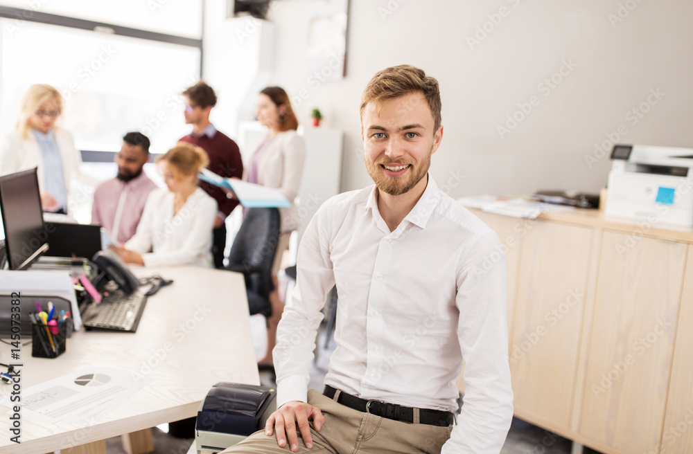happy young man over creative team in office happy young man over creative team in office
