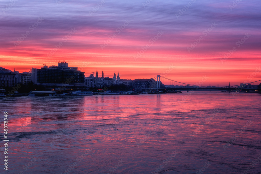 Budapest skyline at dusk, fiery glow of red sunrise with reflection in the Danube river, Hungary, Europe