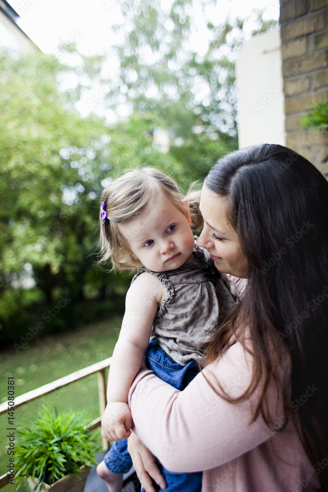 Side view of woman carrying baby girl at balcony Side view of woman carrying baby girl at balcony