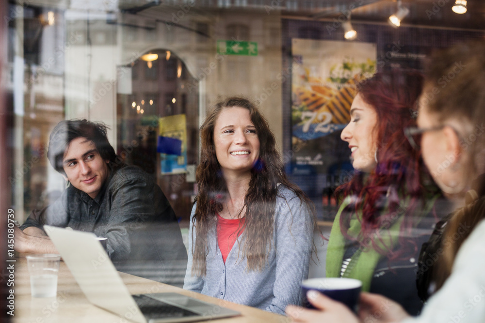 Happy friends enjoying at coffee shop seen from window Happy friends enjoying at coffee shop seen from window