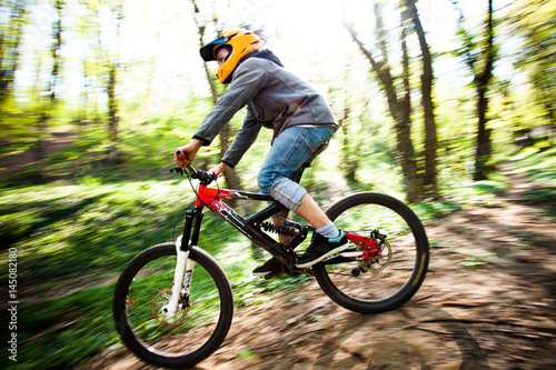 man ride mountain bike through forest