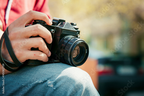 Vintage camera in hand on blurry backround