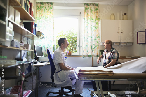 Doctor talking to patient in office at hospital photo